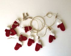 red and white knitted mittens hanging from string