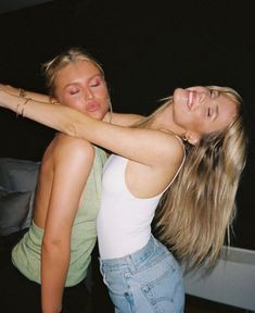 two young women are dancing together on the dance floor at a party, one has her arm around the other's neck