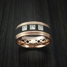 This 14K Rose Gold band features: - 8mm Width- Stepped Bevel Ring Shape- Satin Finish- Patterned Carbon Fiber Inlay-Three Bezel Set .05ct Princess Cut DiamondsThis ring is offered through our website and is part of the MARDINI Series of Innovative Metal rings manufactured by Malo Bands. All of Malo's rings will also include either a "Malo Bands" or "Mardini" Logo, which we cannot remove by request. This ring also has the "Mardini" name plate visible on the exterior of the ring opposite the diamo Luxury Bands With Diamond Accents, Luxury Rose Gold Bands For Formal Occasions, Luxury Formal Rose Gold Bands, Luxury Bands With Diamond Accents For Formal Events, Luxury Rose Gold Bands For Anniversary, Mens Rings Fashion Style, Bevel Ring, Black Diamond Wedding Bands, Viking Wedding