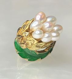 Pearl Leaf Ring, Pearl Bouquet Ring, Enamel Ring, Rare Vintage Pearls, Vintage Gold Ring, Floral Pearl Ring, Solid Gold Ring, Gift for Her This charming piece is a true work of art. Featuring a cluster of 8 elongated pearls arranged as a bouquet of flowers surrounded with solid gold and green enamel leaves set on an angle in 14k yellow gold. * Ring size in 6 3/4 Unique Yellow Gold Enamel Ring For Anniversary, Formal White Enamel Rings, White Enamel Wedding Rings, Elegant White Enamel Wedding Ring, Green Enamel Ring For Wedding, Enamel Flower Ring For Wedding, Hallmarked Enamel Jewelry For Weddings, Elegant White Oval Enamel Ring, White Luxury Enamel Wedding Ring