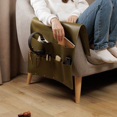 a woman sitting on a chair with her purse in it's lap and the contents inside