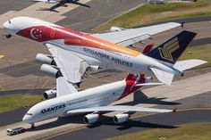 two airplanes are parked on the tarmac at an airport, with other planes in the background