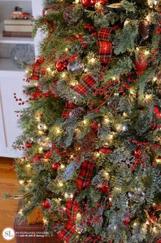 the christmas tree is decorated with red, green and white plaid ribbon on it's branches