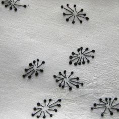 black and white snowflakes are on a white cloth with small dots in the middle