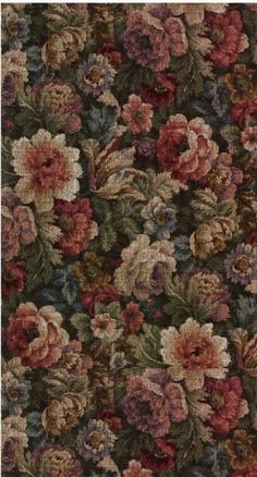 an area rug with flowers and leaves in various colors on the ground, including red, brown