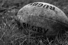 an old rugby ball sitting in the grass with words written on it's side