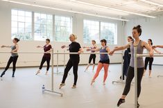 a group of young women standing next to each other in a dance studio