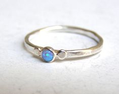 OPAL RING You are looking at a beautiful HAND MADE silver ring with opal stones. The stones are setting in silver bezel. It is impressive, powerful and very beautiful ring. made to order any size This ring can be made to order in any size. Please note your desired size in the message to seller area at checkout. size opal is 3mm Half round silver ring 2.5 mm Come in a gift box. Fallow me on facebook for newest updates. http://www.facebook.com/pages/Orit-Naar-jewelry/174677569247132?sk=wall Elegant Silver Opal Stackable Rings, Stackable Opal Ring With Round Band In Sterling Silver, Handmade Sterling Silver Opal Promise Ring, Silver Opal Stackable Rings As Gift, Silver Opal Birthstone Ring Gift, Silver Opal Ring With Polished Finish, Silver Stackable Opal Promise Ring, Sterling Silver Opal Ring With Bezel Setting As Gift, Unique Sterling Silver Opal Ring Birthstone