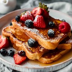 french toast with berries and powdered sugar on a plate