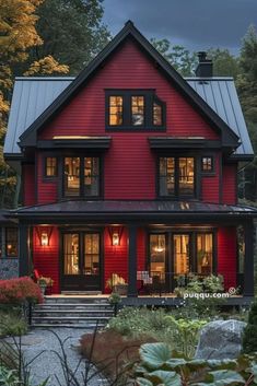 a red house is lit up at night with lights on the front and side windows