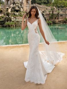 a woman in a wedding dress is posing for the camera