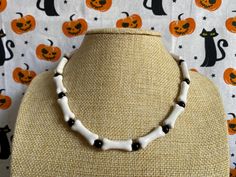 Happy Halloween! Celebrate spooky season with Dot & Moo necklaces - the finishing touch to your costume, or maybe a subtle costume in itself! This necklace is made of handmade ceramic bone-shaped beads, and is securely fastened with a lobster claw closure and signature D&M bell accent. Check out the entire Halloween collection on our store! Adjustable White Jewelry For Halloween, White Adjustable Jewelry For Halloween, Beaded Halloween Necklace, Handmade Bone Jewelry For Halloween, Halloween Necklace With Round Beads, Adjustable Beaded Necklace For Halloween, Halloween Adjustable Round Bead Necklaces, Edgy Handmade Halloween Necklaces, Unique Handmade Halloween Necklaces