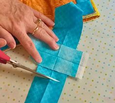 a person cutting fabric with scissors on a table