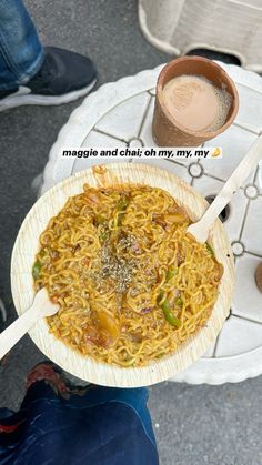 a person holding a wooden spoon over a bowl of noodles with sauce on the side