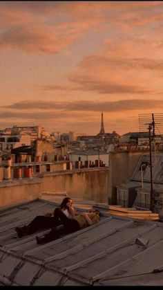 two people sitting on the roof of a building