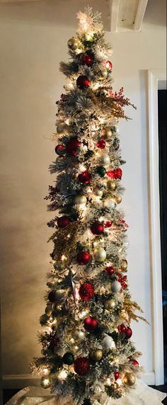 a white christmas tree with red and silver ornaments