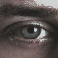 a man's eye is shown in this close up photo, with only the upper part of his face visible