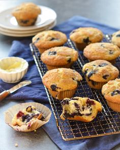 blueberry muffins are cooling on a rack with butter and other dessert items