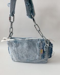 an old pair of jeans is being held by a metal chain and has been used as a purse