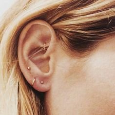 a woman's ear with two piercings on it