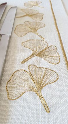 a close up of a table cloth with flowers on it and a pair of scissors