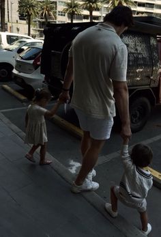 a man walking down the street with two children