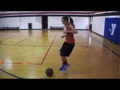 a girl is playing with a ball in an indoor gym