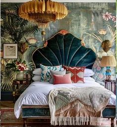 a bedroom with a bed, chandelier and paintings on the wall behind it