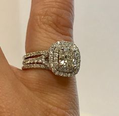 a close up of a person's hand with a diamond ring on their finger