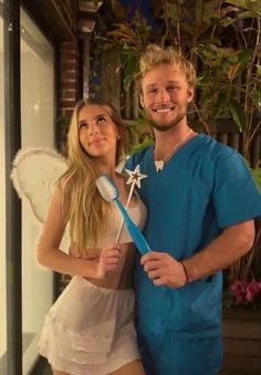 a man and woman dressed up in costumes posing for a photo with a toothbrush