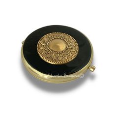 an antique black and gold pill box