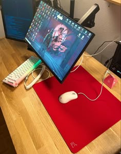 a computer monitor sitting on top of a wooden desk next to a keyboard and mouse