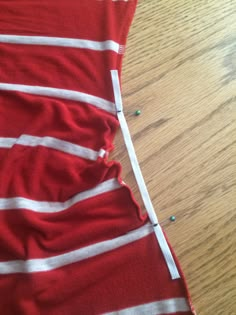 a piece of red and white fabric on top of a wooden floor