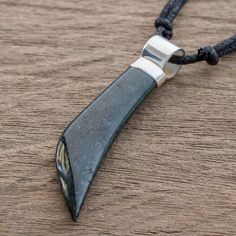 a knife shaped pendant on a black cord