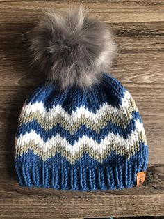 a blue and white hat with a fur pom