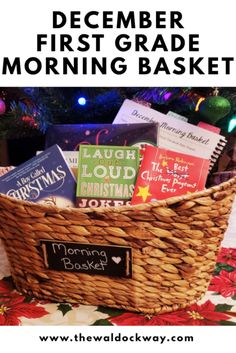 a basket filled with books sitting on top of a table next to a christmas tree