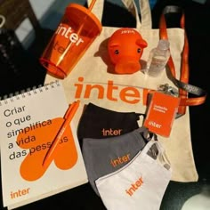 the contents of an orange and white tote bag are displayed on a counter top