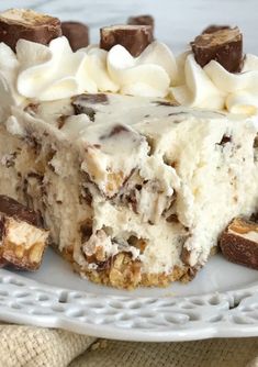 a piece of cake with white frosting and chocolate chips on top is sitting on a plate