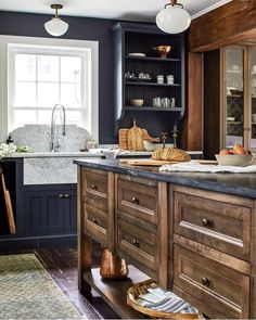 a kitchen with blue walls and wooden cabinets