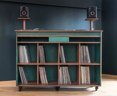 a record player sitting on top of a wooden shelf filled with vinyls and records