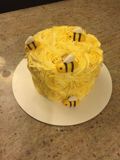 a cake with yellow frosting and bees on it