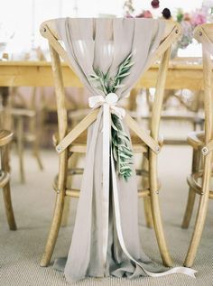 the back of a wooden chair with a white sash on it