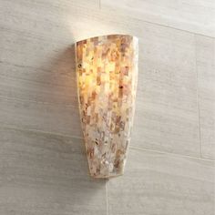 a wall light that is mounted to the side of a wall with a mosaic pattern on it