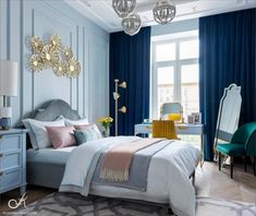 a bedroom with blue walls and white bedding, chandelier, chair, desk and mirror