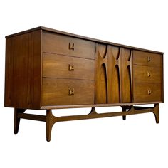 a wooden cabinet with four drawers and two handles on the front, against a white background