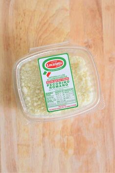 a plastic container filled with rice on top of a wooden table