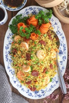 a plate full of rice with shrimp and carrots on it next to other dishes