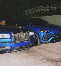 two blue sports cars parked next to each other