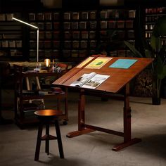 a wooden table sitting in the middle of a room next to a chair and lamp