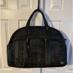 Lug Black Oversized Quilted Front Airbus Travel Bag. 3 Zip Pockets In The Front, 1 Very Large Zipper In The Back, 1 Zipper & Elastic Pocket On Side And 1 Large Mesh Zipper Shoe Pocket On Other Side. There Is Also 2 Large Elastic Pockets On One Inner Wall And 1 Large Zipper Pocket On The Other Inside Wall. There Is Room To Carry And Store So Many Items In This Carry On Oversized Bag. 100% Polyester Which Can Easily Be Wiped Clean. Approximately 19 3/4”W X 14”H X 9”D With A Handle Drop Of 5 1/2”. Black Travel Bag With Removable Pouch, Black Travel Bag With Removable Pouch For Trips, Black Double Handle Bag For Overnight Trips, Black Luggage With Removable Pouch For Trips, Black Duffle Bag With Removable Pouch For Trip, Versatile Black Bag For Trips, Versatile Black Bags For Trips, Black Shoulder Weekender Bag For Overnight Trips, Black Tote Weekender Bag For Trip